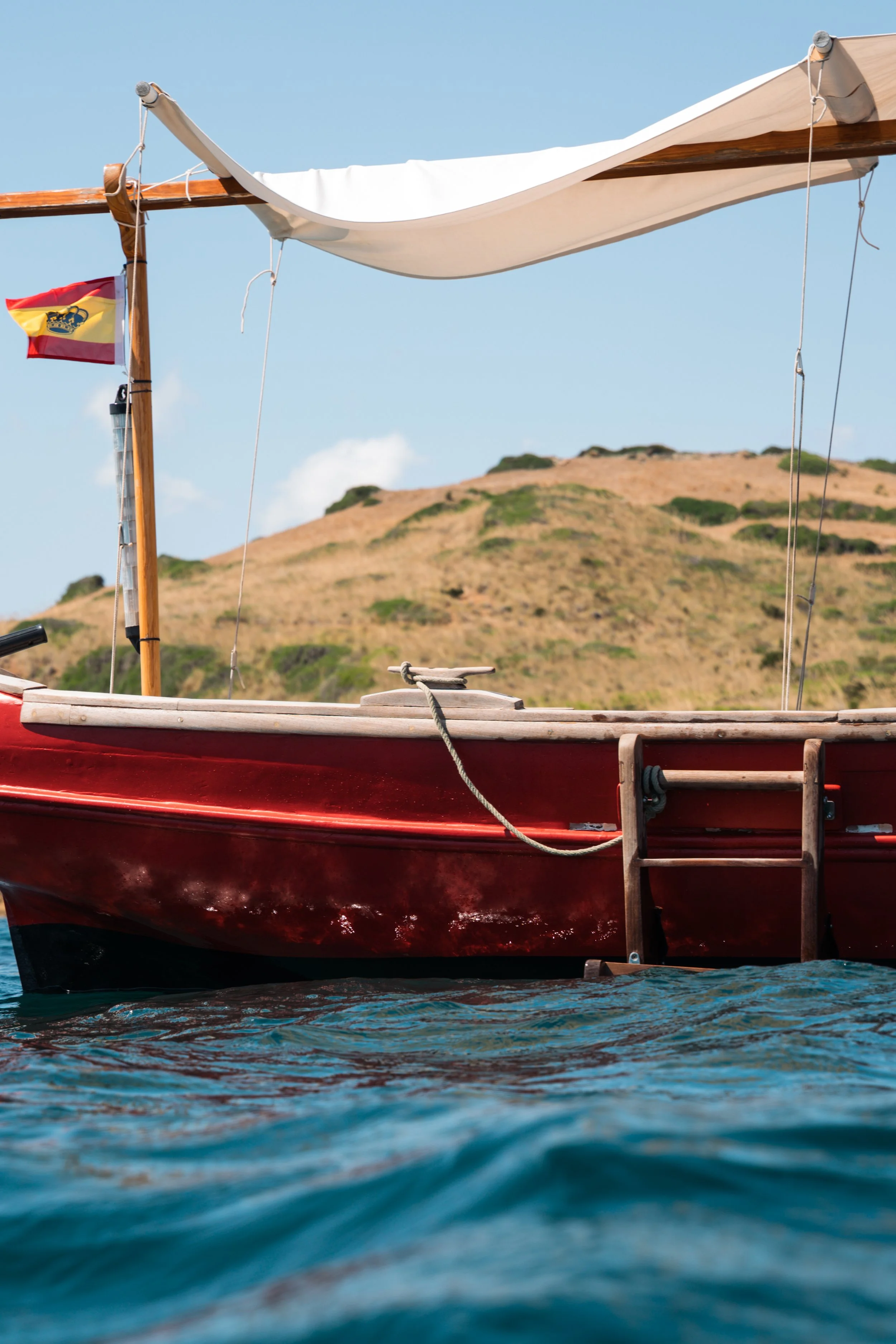 Llaüt con bandera española en el norte de Menorca